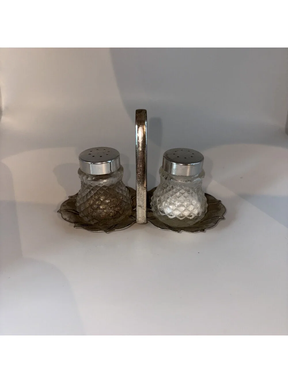 Miniature glass salt and pepper shakers with chrome lids and base holder